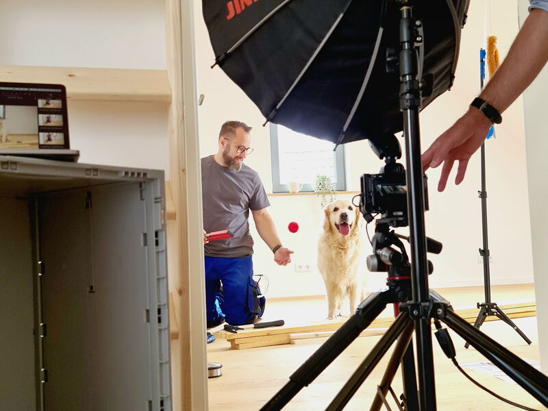 Dargestellt ist ein Fotoshooting der Schwalm-Aue zur Kampagne Möglichmachen mit einem Mann als Handwerker und einem Hund im Hintergrund
