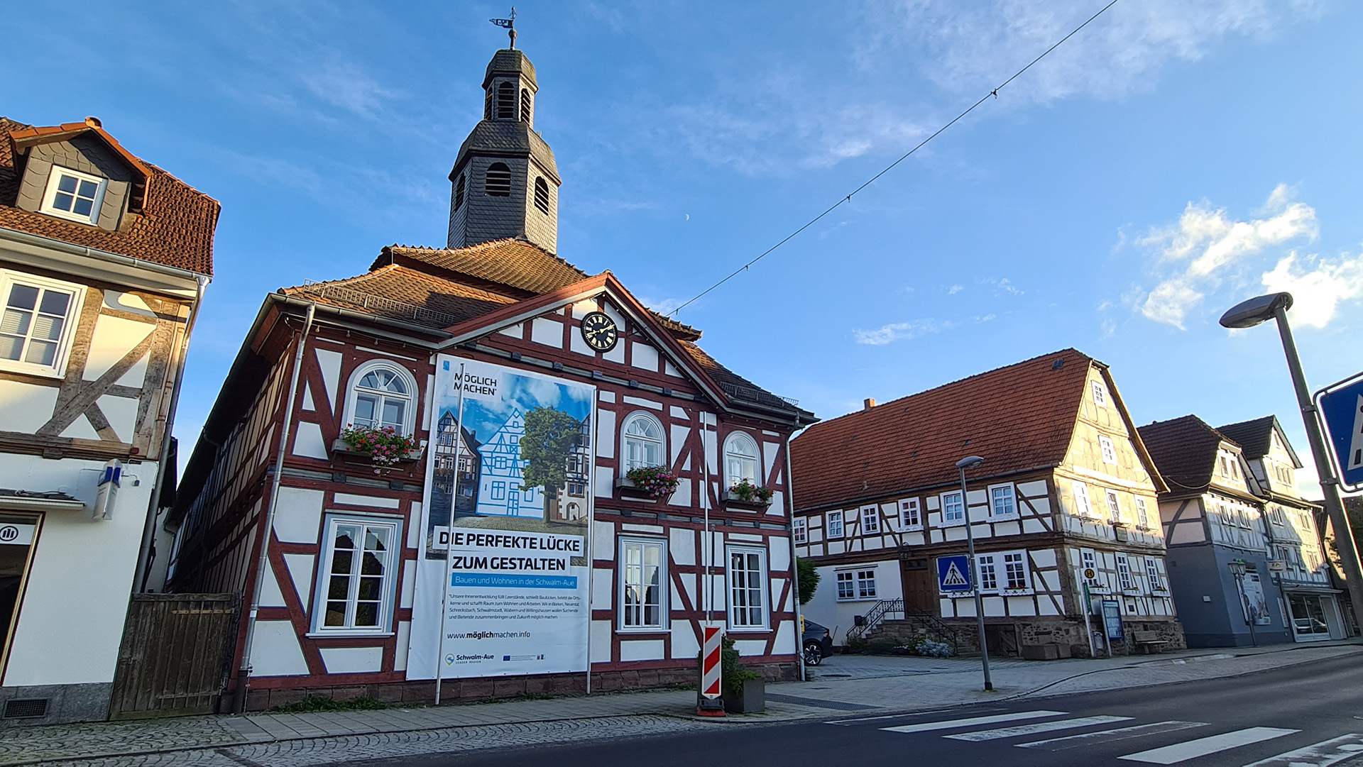 Ein großes Werbeplakat der Schwalm-Aue hängt an einem Fachwerkhaus zu der Kampagne Möglichmachen